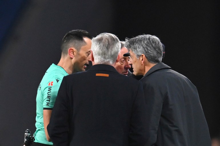 Referee Jose Maria Sanchez Martinez, left, Real Madrid's head coach Carlo Ancelotti, centre, Real Sociedad's head coach Imanol Alguacil, right, talk during the Spanish Copa del Rey soccer match between Real Sociedad and Real Madrid at the Reale Arena in San Sebastian, Spain, Wednesday, Feb. 26, 2025. (AP Photo/Miguel Oses)