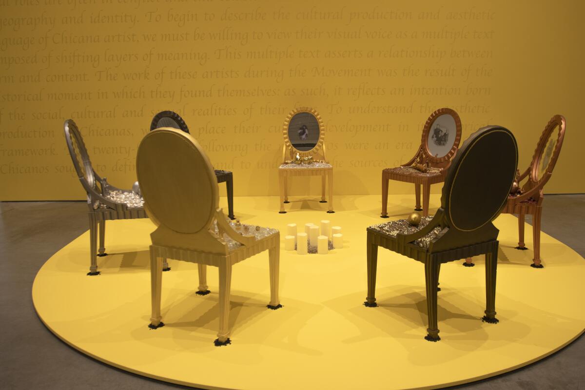 An art piece with chairs and candles on a yellow setting