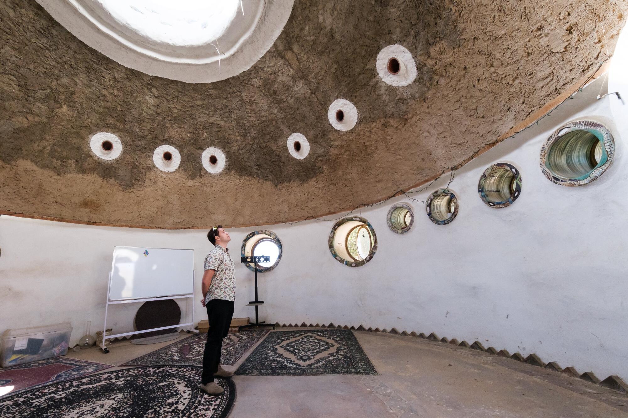 Justin Schachter admires a SuperAdobe structure during a tour at CalEarth.