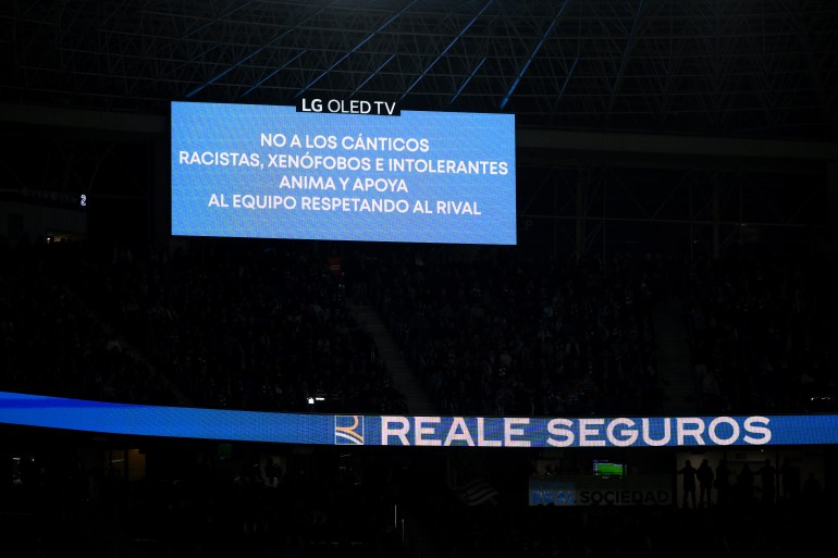 SAN SEBASTIAN, SPAIN - FEBRUARY 26: The LED board states "No to racist, xenophobic and intolerant chants, encourage and support the team while respecting the rival" following an incident involving Vinicius Junior (not pictured) and fans during the Copa del Rey Semi Final match between Real Sociedad and Real Madrid at Reale Arena on February 26, 2025 in San Sebastian, Spain. (Photo by David Ramos/Getty Images)