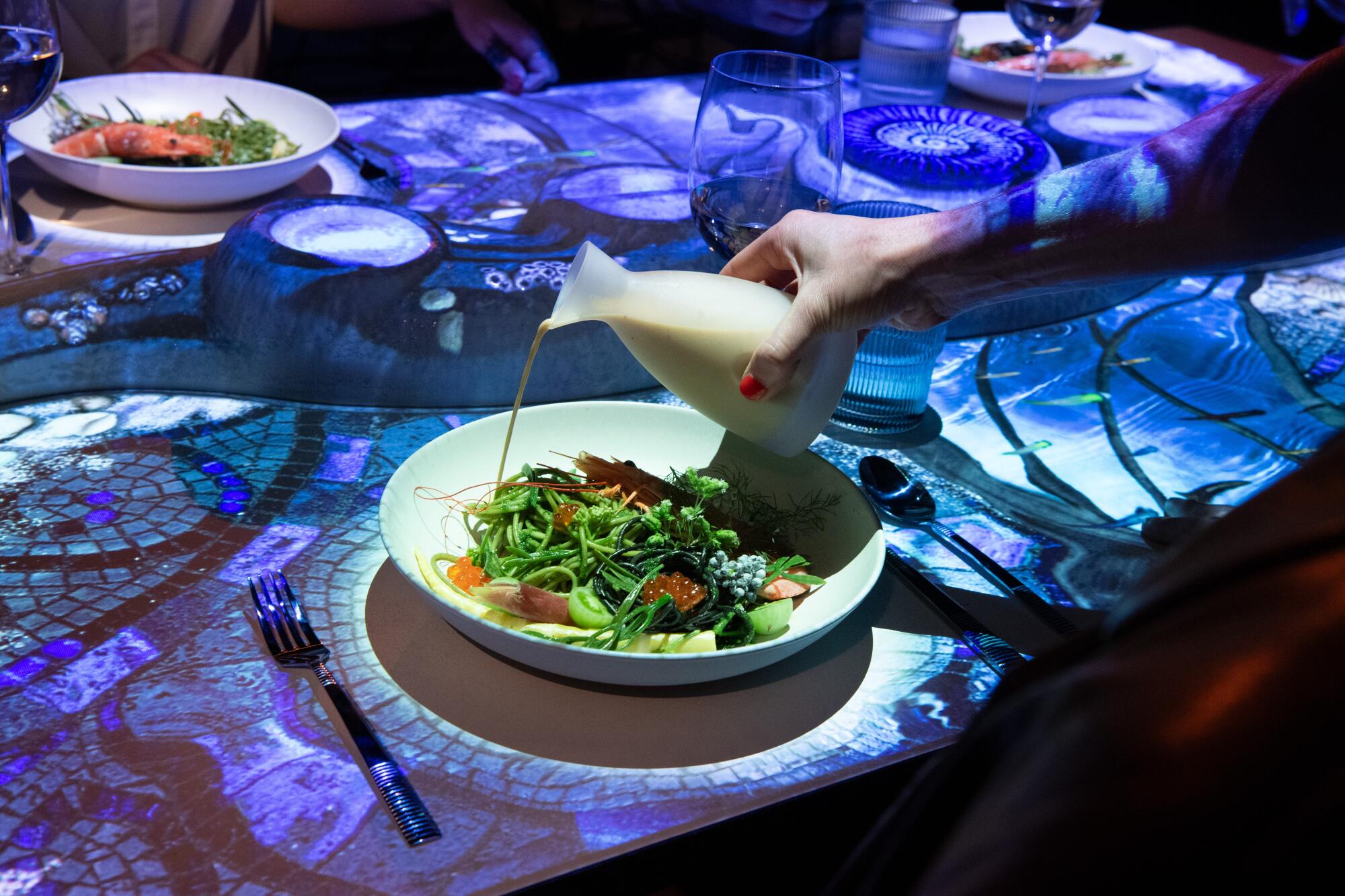 A salad with dressing being poured.