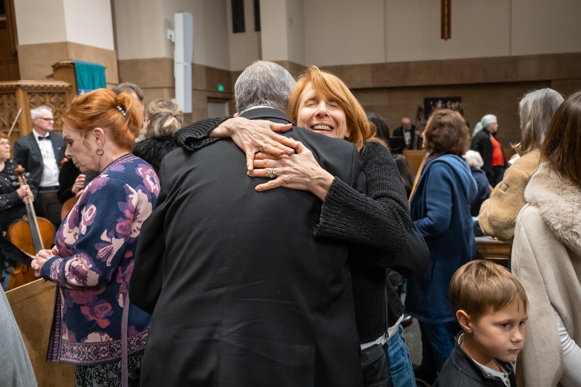 Debbie Rafei hugs her cousin who lost his home in the Palisades Fire, during intermission.