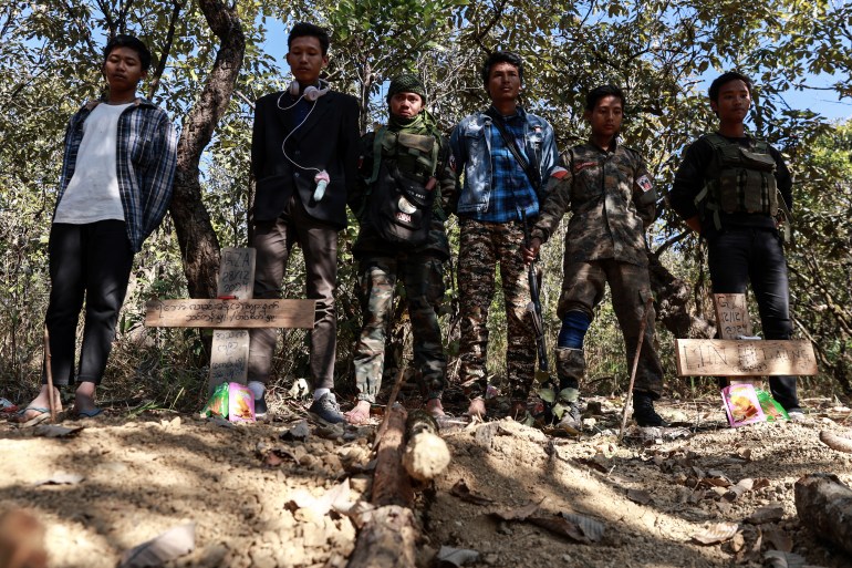 Chin National Defence Force (CNDF) fighters stand near the fresh graves of fallen comrades in Falam township, Chin State, Myanmar, December 31, 2024.