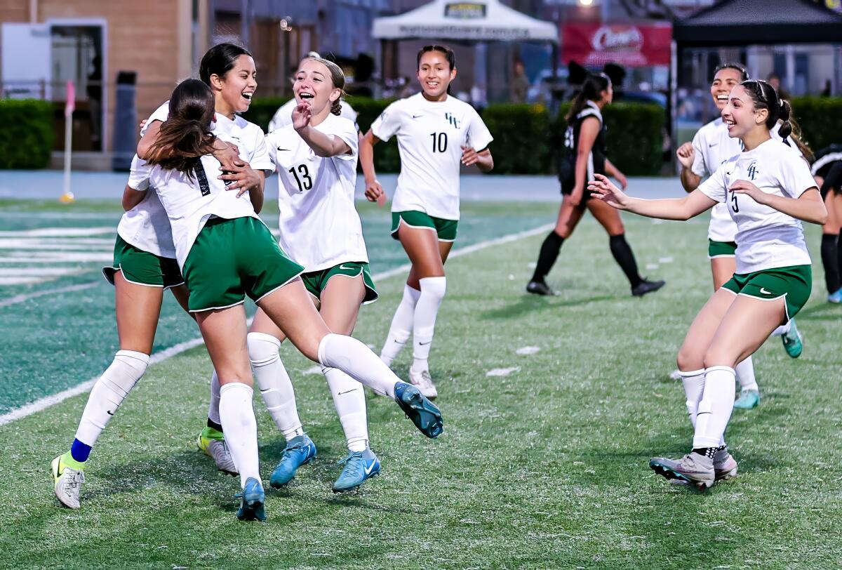 Illiana Velazco, left, is swarmed by Granada Hills High teammates after scoring a goal against Cleveland on Friday night.