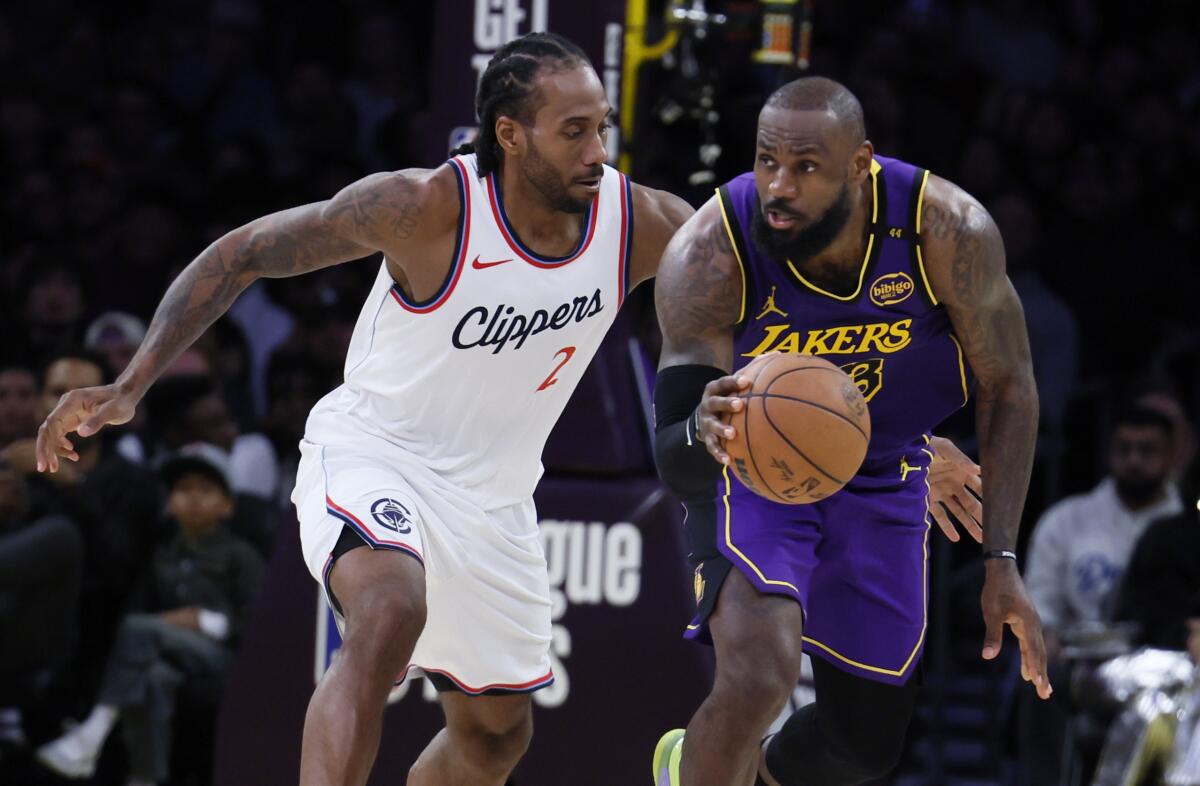 Lakers forward LeBron James tries to break away from Clippers forward Kawhi Leonard late in the fourth quarter Friday.