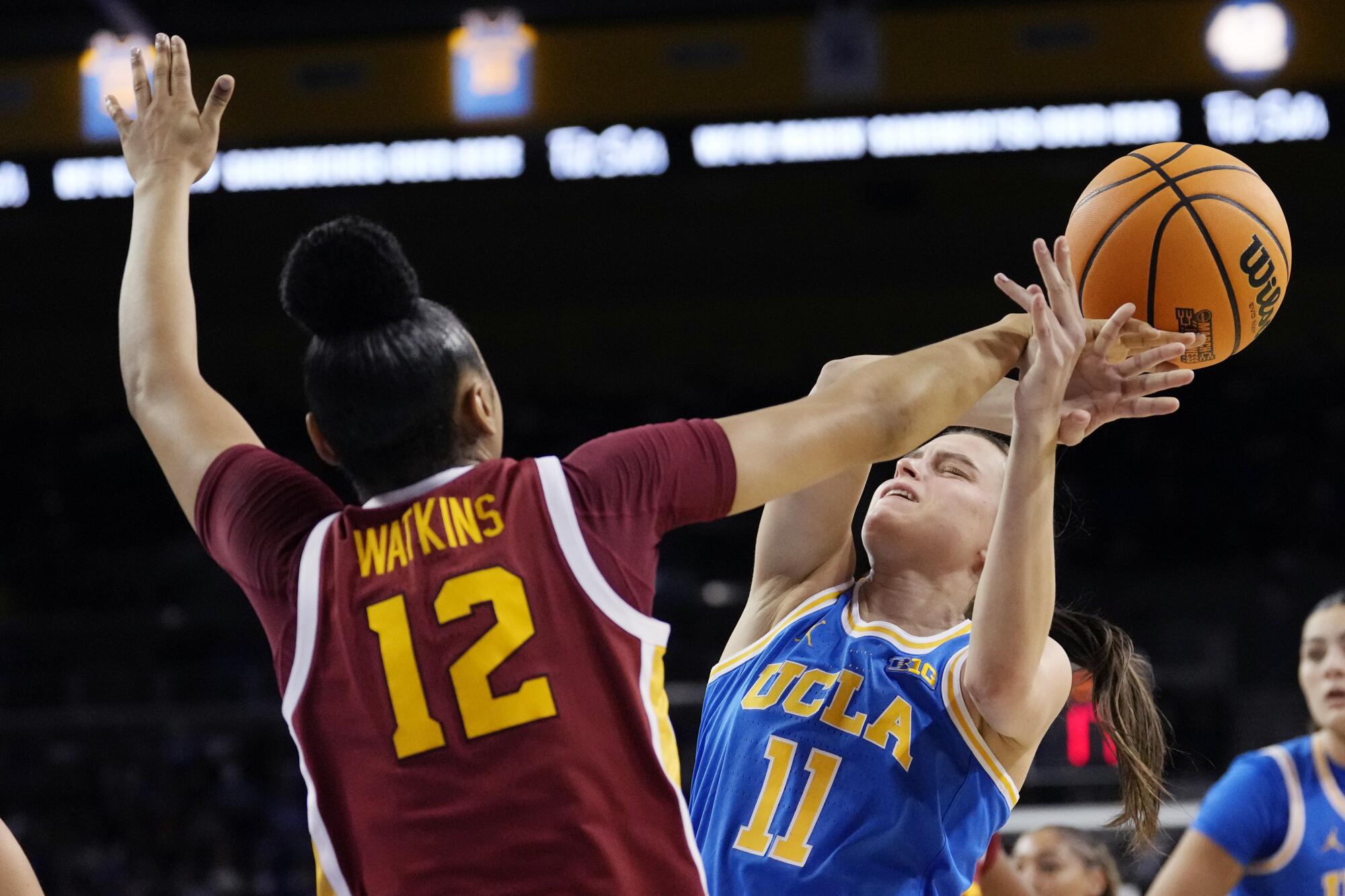 USC guard JuJu Watkins, left, blocks a shot by UCLA guard Gabriela Jaquez during the first half Saturday.