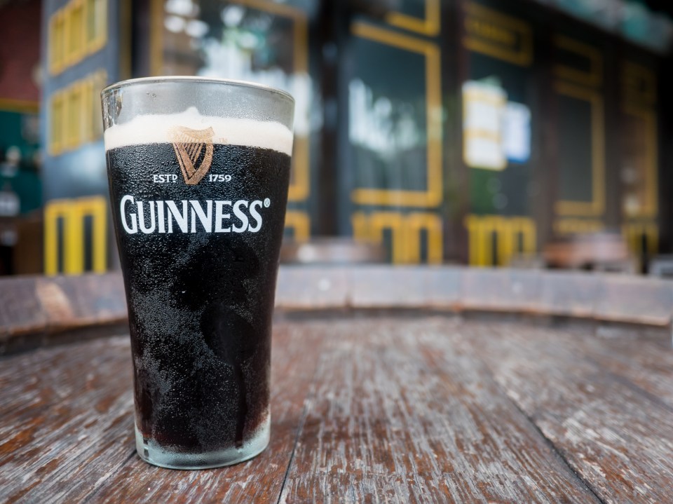 Pint of Guinness on a wooden table.