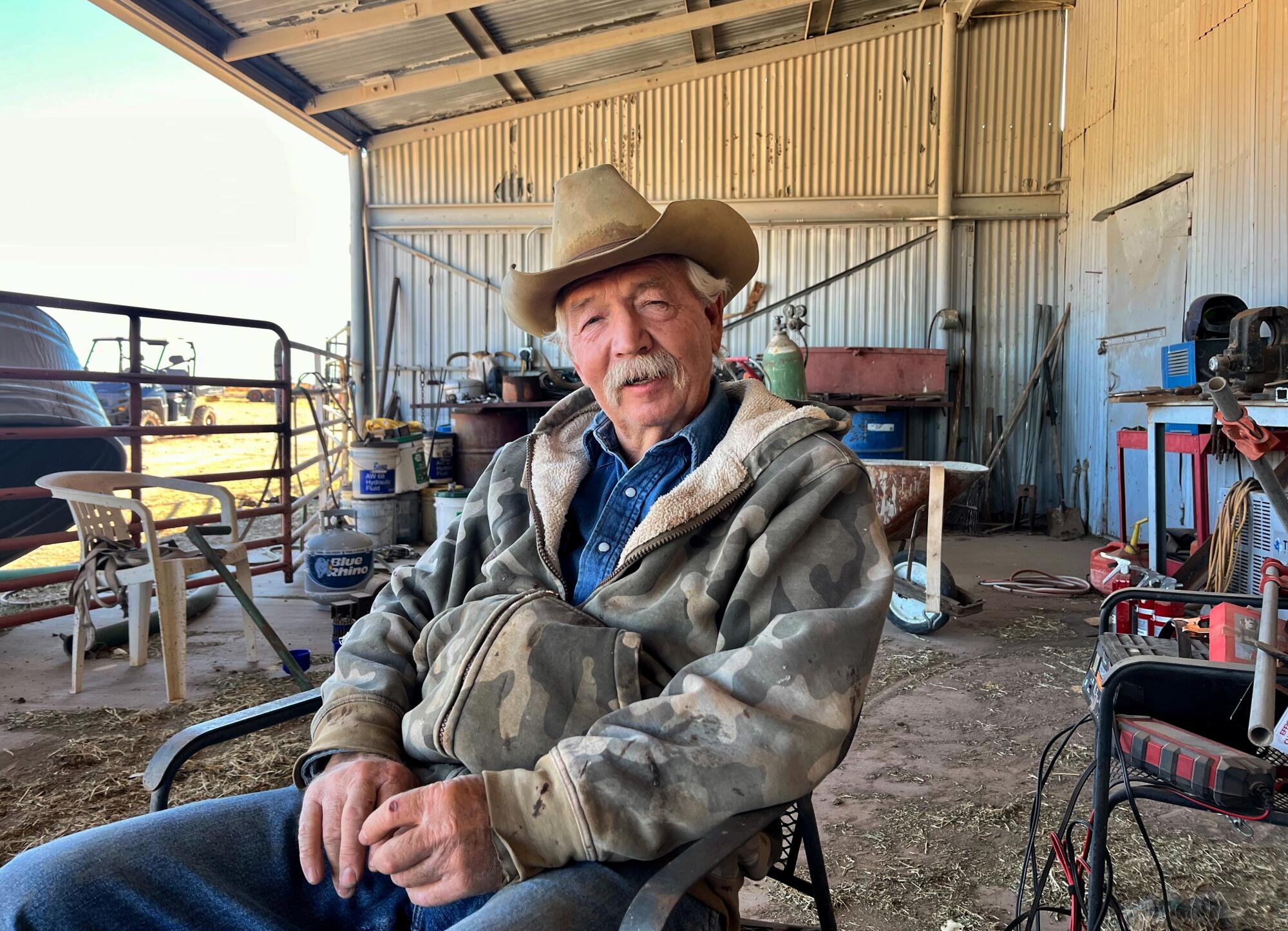 Rancher John Ladd seated in a corral discussing life on the border.