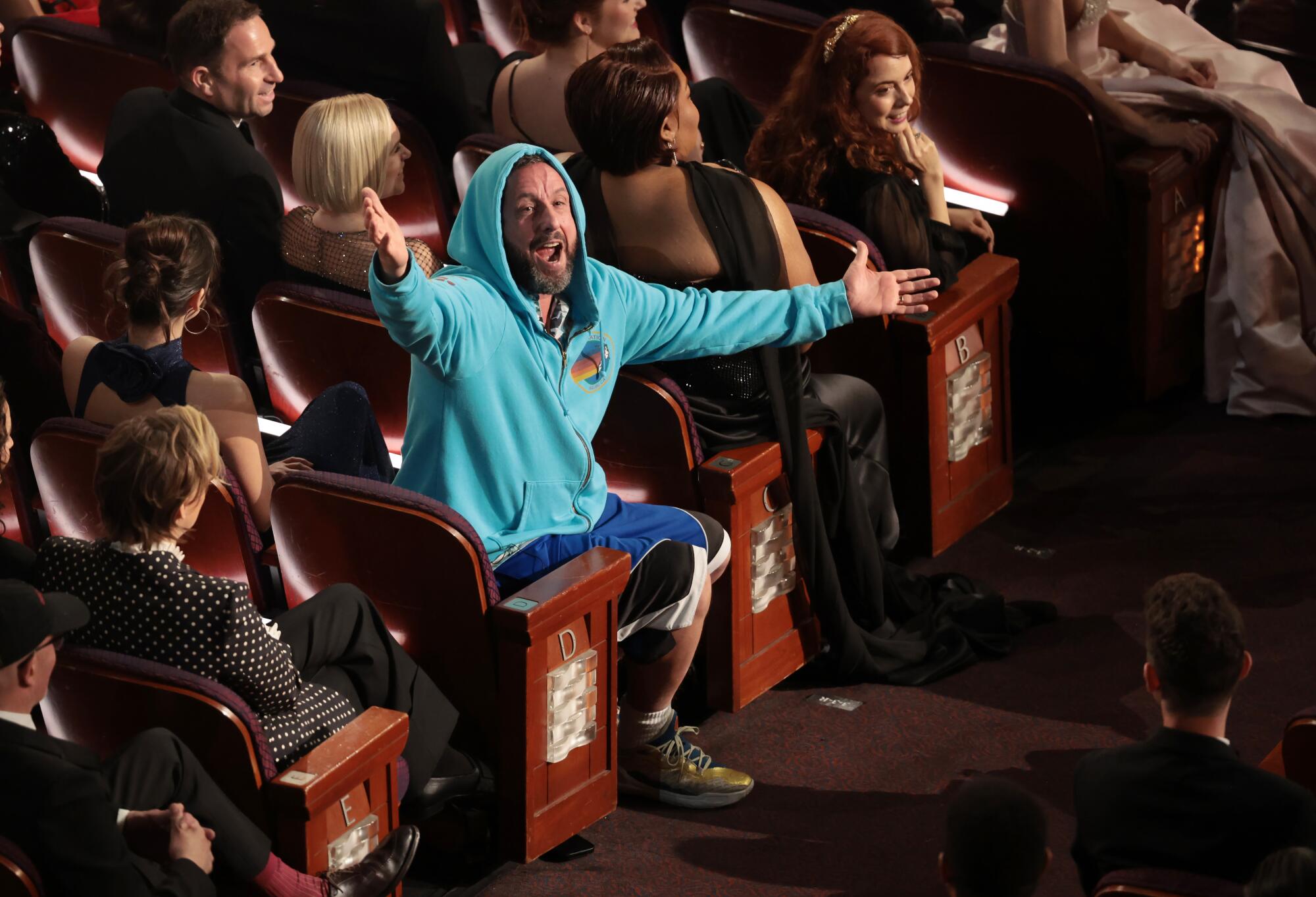 A seated man wearing a hoodie.