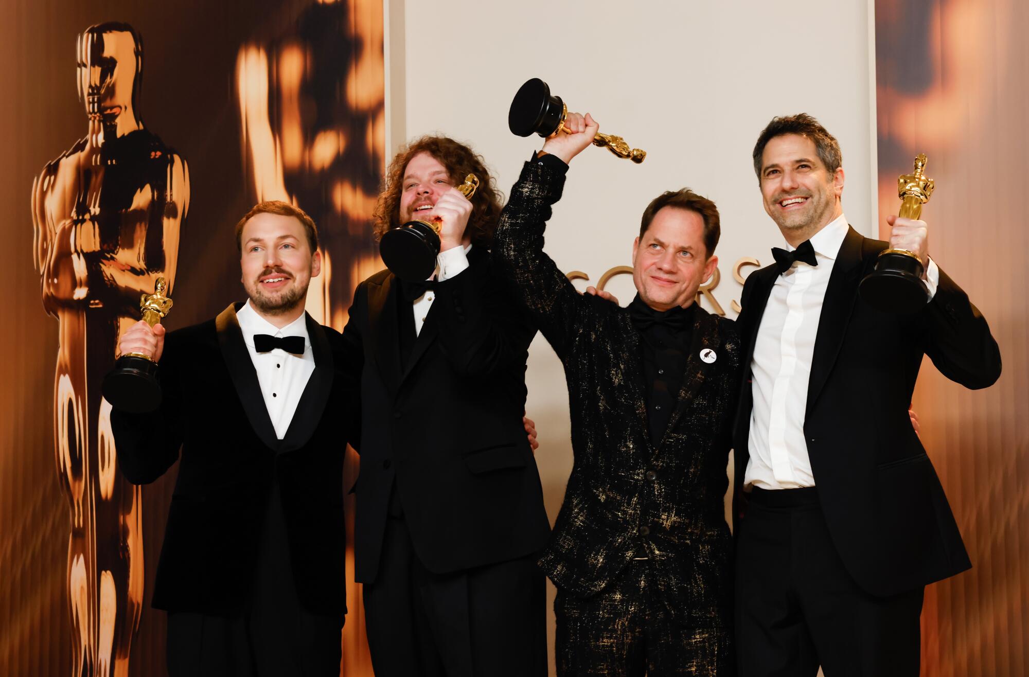 Four "Flow" filmmakers raise their Oscars.