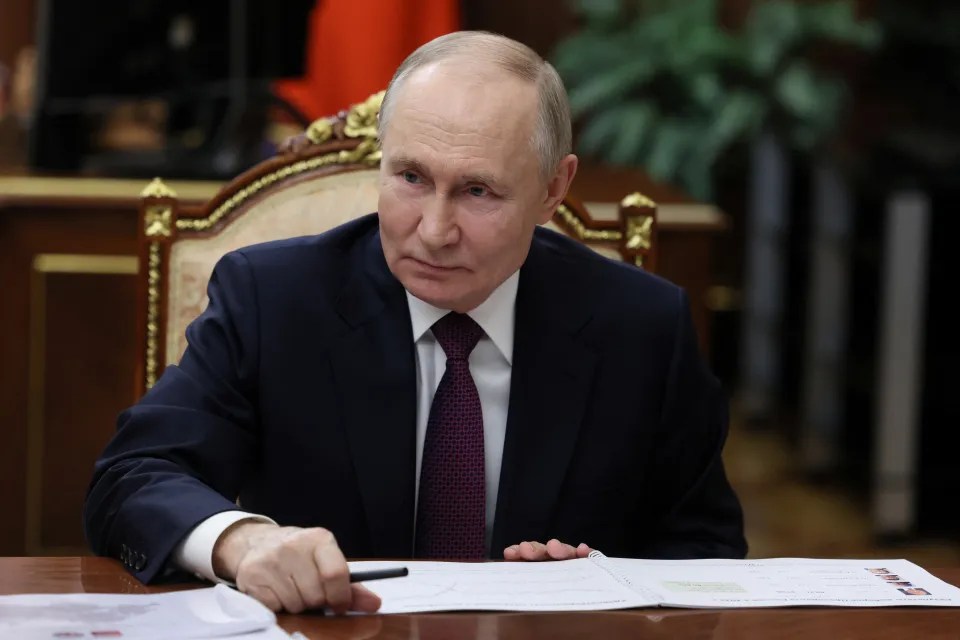 Vladimir Putin reviewing documents.