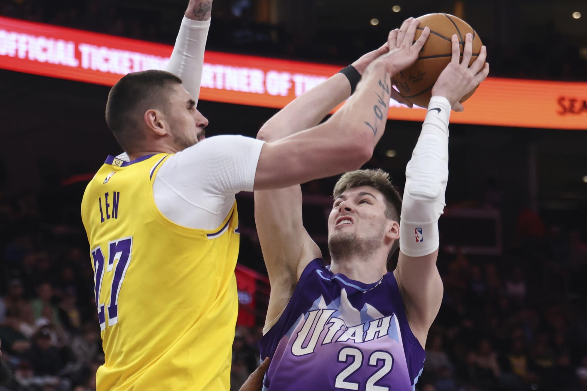 Lakers center Alex Len blocks a shot by Utah Jazz forward Kyle Filipowski on Feb. 12 in Salt Lake City. 