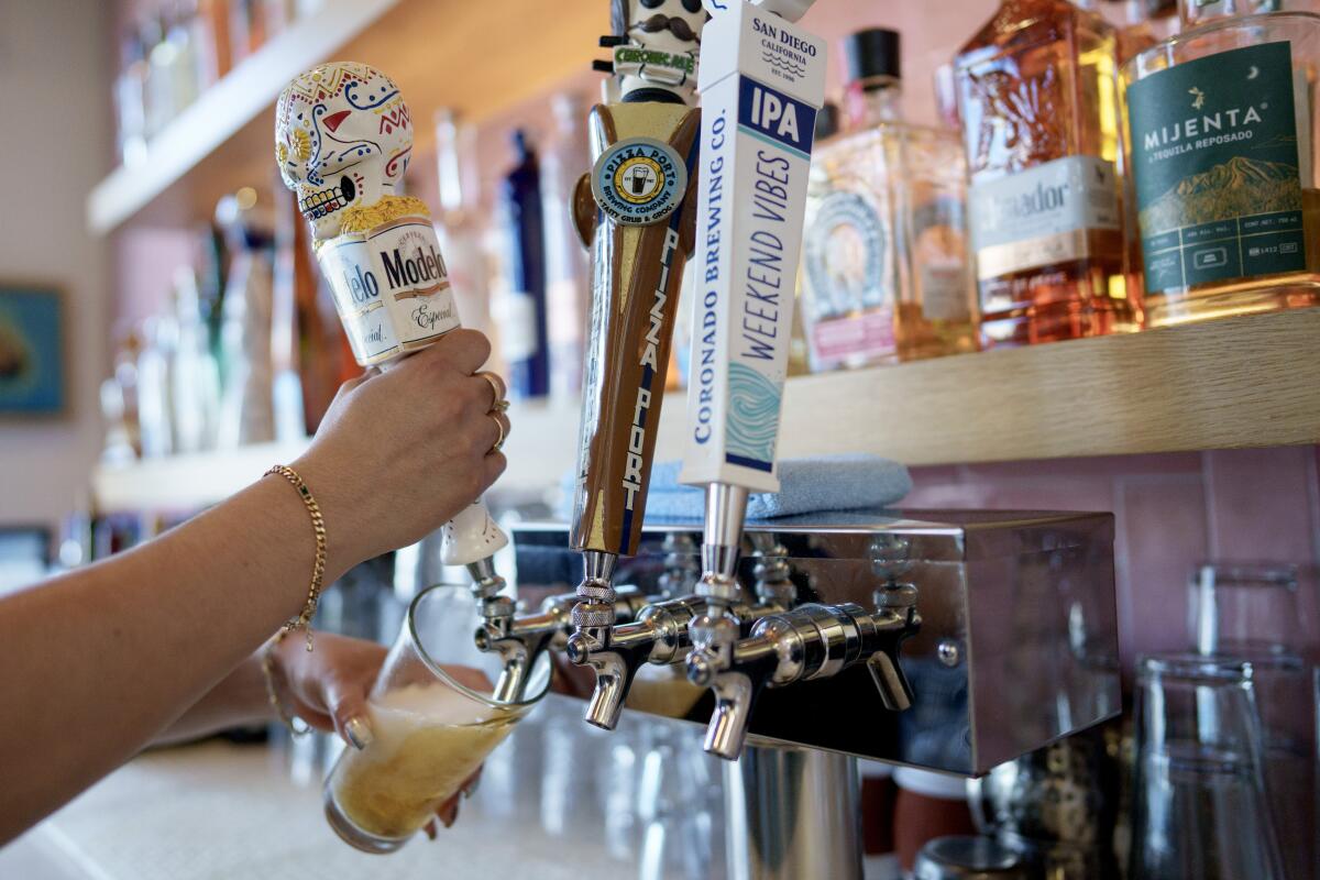 Filling a beer glass from a tap at Lola's restaurant in Long Beach.