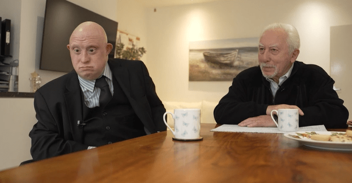 Two men sitting at a table, drinking tea.