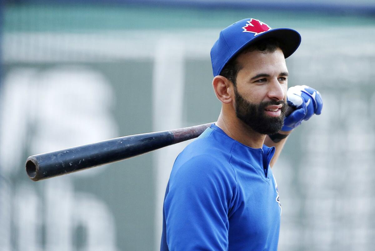 Former major leaguer Jose Bautista holds a bat over his shoulder before a game in 2017.