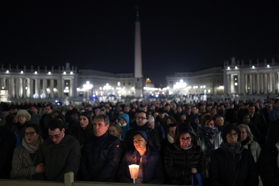 Large crowd of people holding candles during a prayer service in St. Peter's Square.