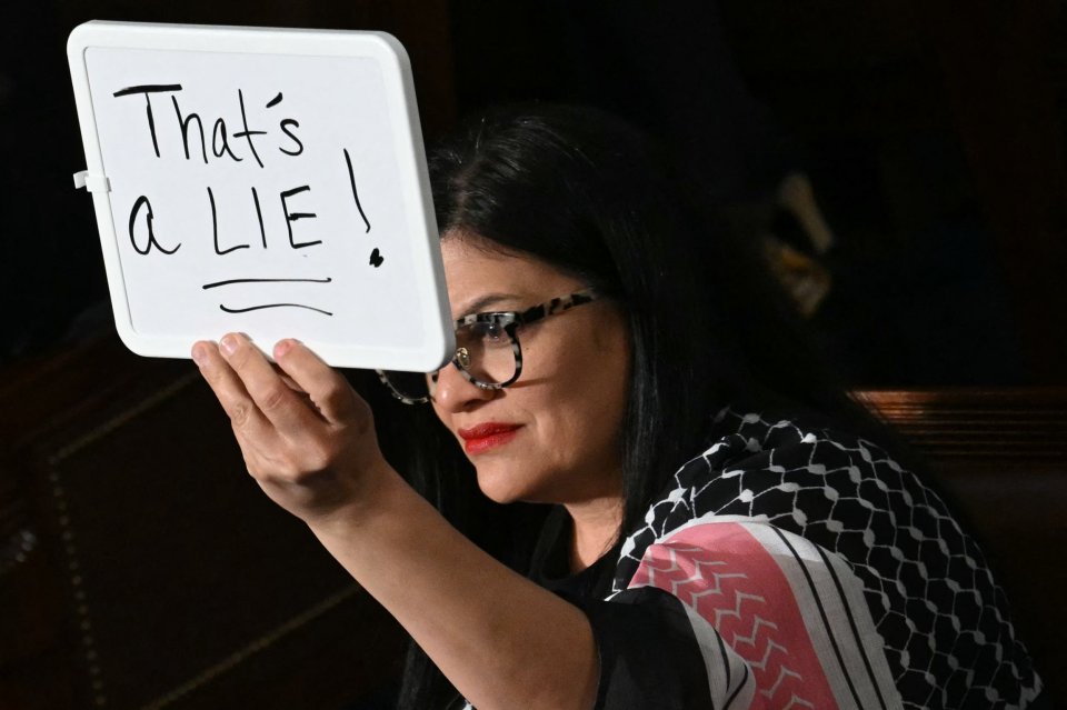 Rep. Rashida Tlaib holding a whiteboard that says "That's a lie!" during a presidential address to Congress.