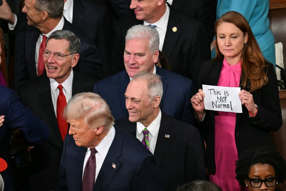 Rep. Melanie Stansbury holding a sign reading "This is Not Normal" as President Trump addresses Congress.