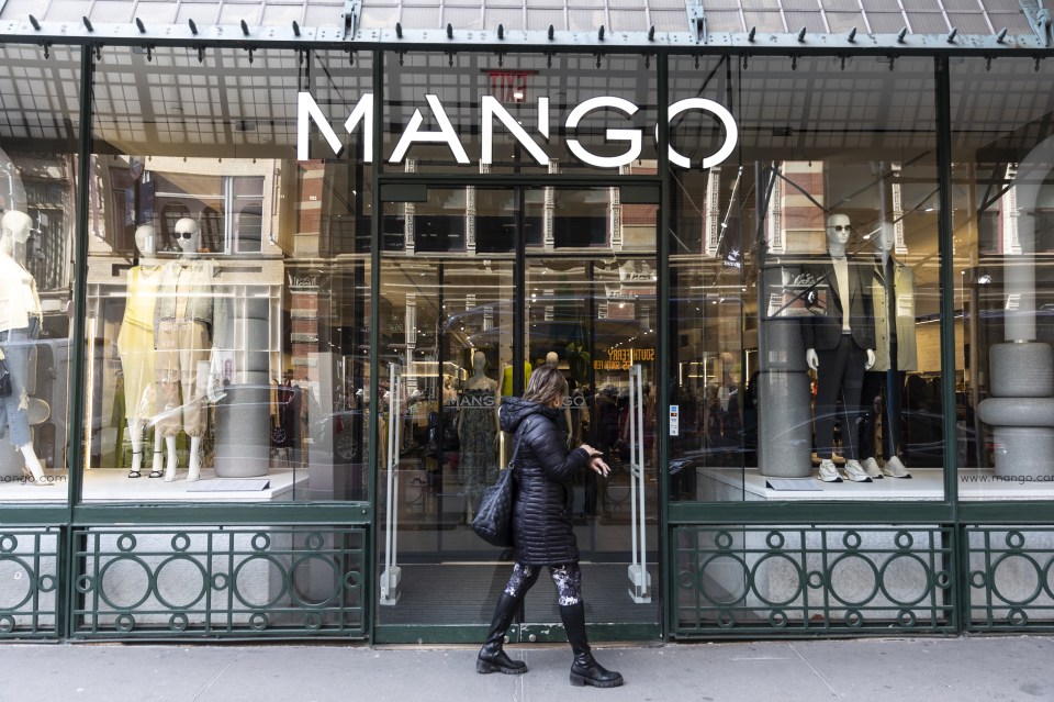 A woman walks past a Mango clothing store in New York City.