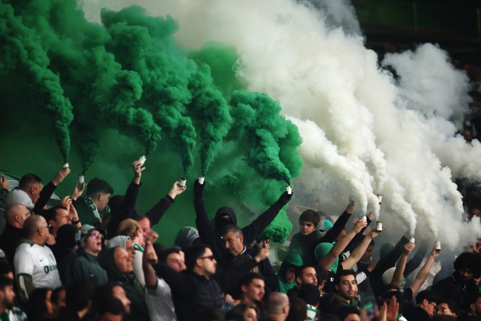 Sporting CP fans using green and white smoke flares at a soccer match.