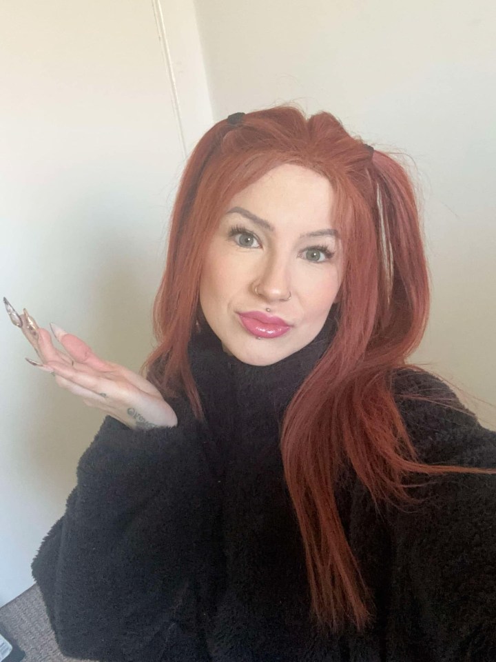 Woman with long red hair in pigtails, wearing a black sweater, expressing dislike for World Book Day.