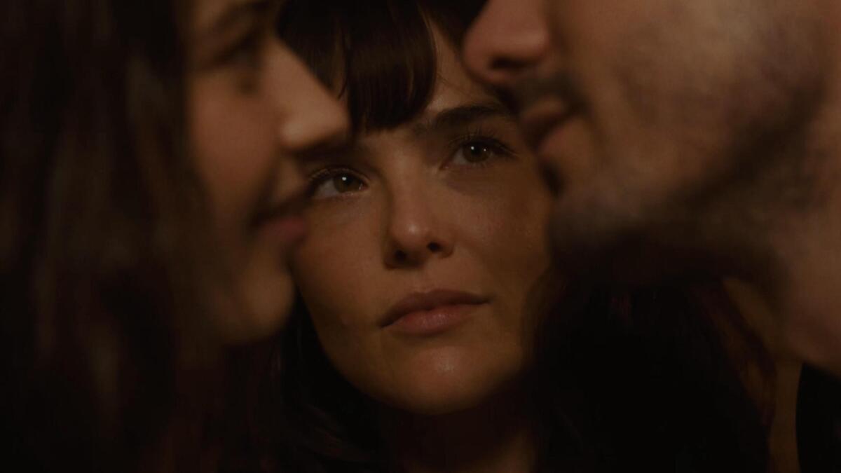 A very closeup photo of three people's faces close together