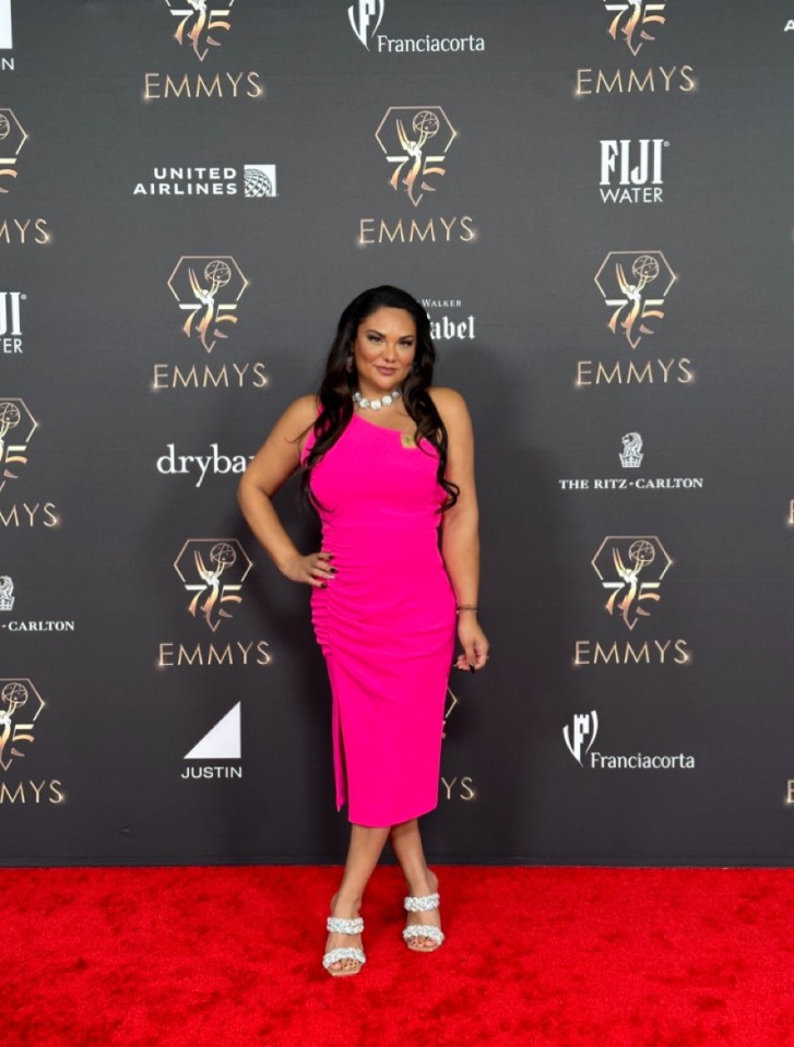 Woman in pink dress at Emmy Awards.