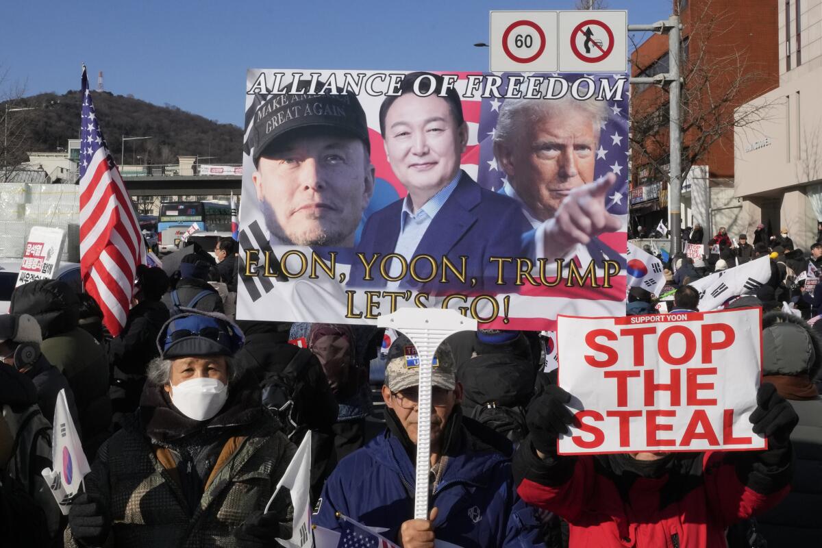 A supporter of impeached South Korean President Yoon Suk Yeol holding up a sign 