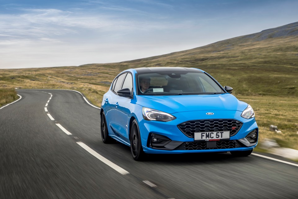 Blue Ford Focus ST Edition driving on a winding road.