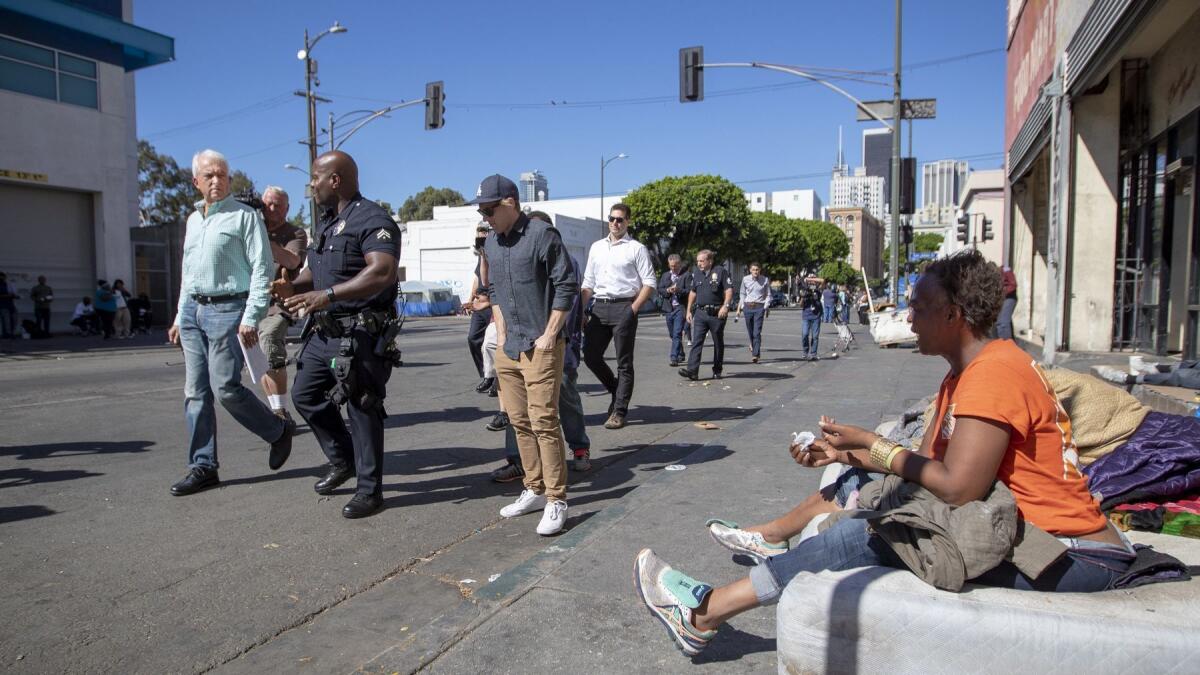 Republican gubernatorial candidate John Cox, left, talks about homelessness and affordable housing on Oct. 16 with LAPD Officer Deon Joseph, who is assigned to the L.A.'s skid row.