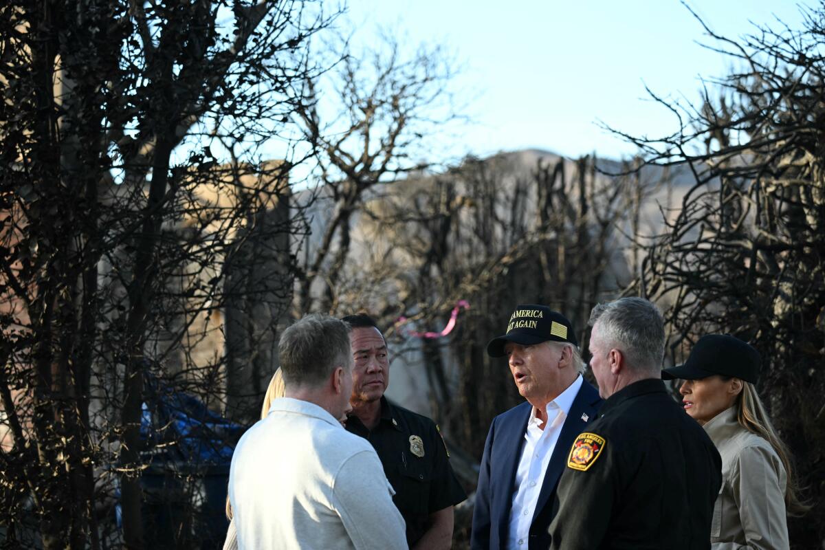 President Trump speaks with officials during a January tour of Pacific Palisades fire damage.