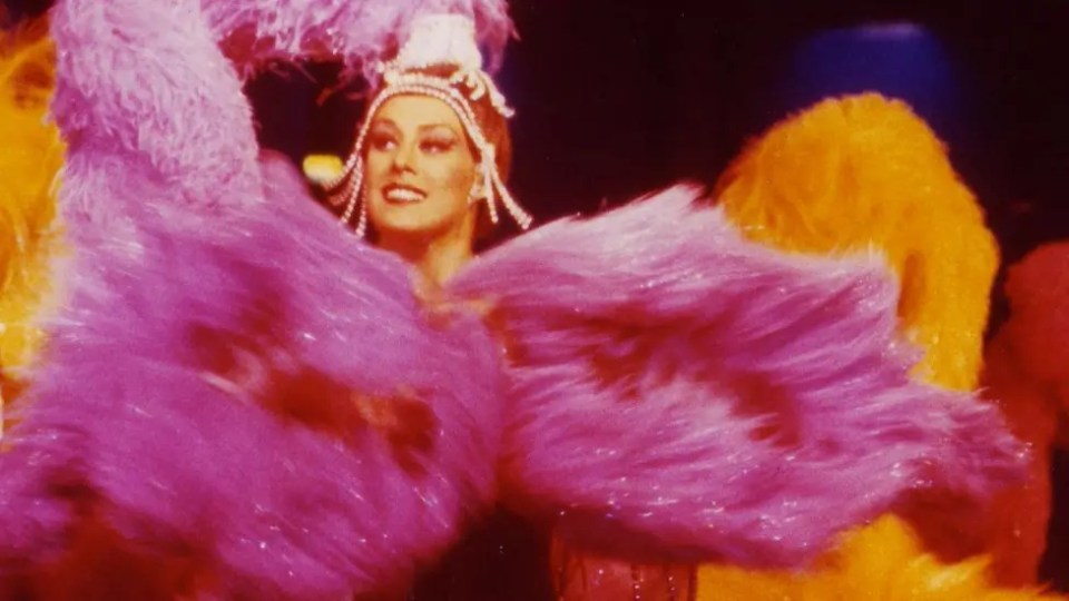 Photo of Janet Pharaoh, artistic director of the Moulin Rouge, in a feathered costume.