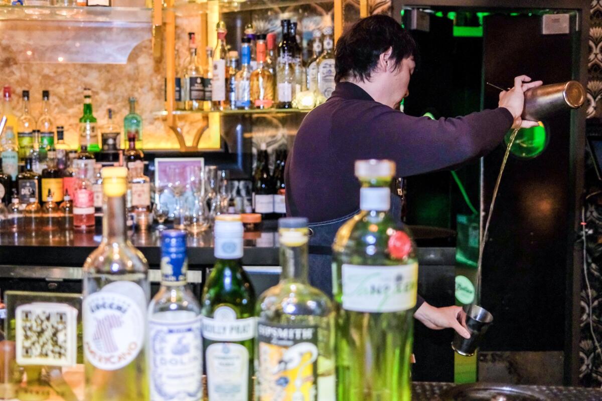 Chris Lee, head bartender at Realm of the 52 Remedies, makes a thrown martini.