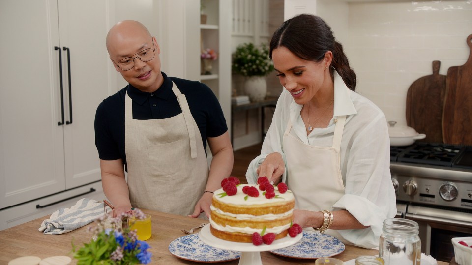 Meghan Markle and Daniel Martin decorating a cake.