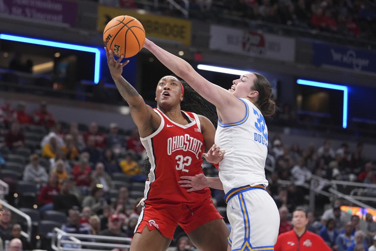 UCLA forward Angela Dugalic, right, uses her left hand to block a right-handed layup by Ohio State forward Cotie McMahon.