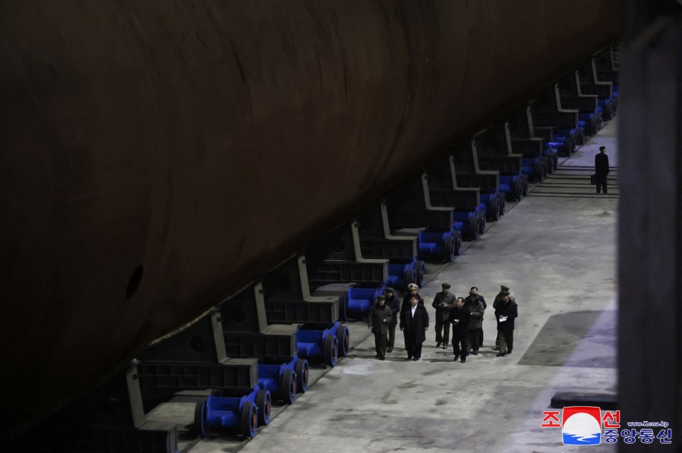 Kim Jong Un inspecting a nuclear submarine in a shipyard.