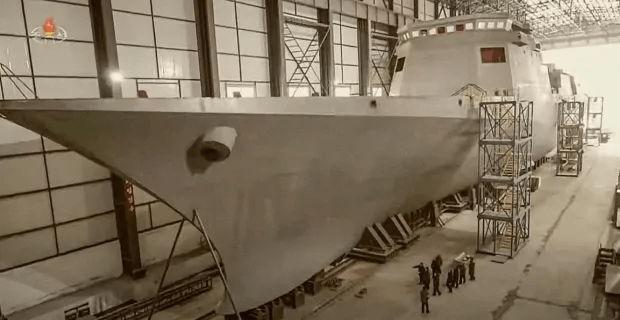 Warship under construction in a shipyard.