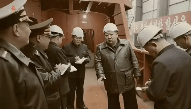 Kim Jong-un and officials inspecting a shipyard.