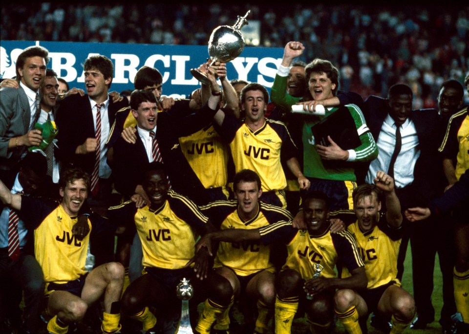 Arsenal team celebrating a title win on the Anfield pitch.