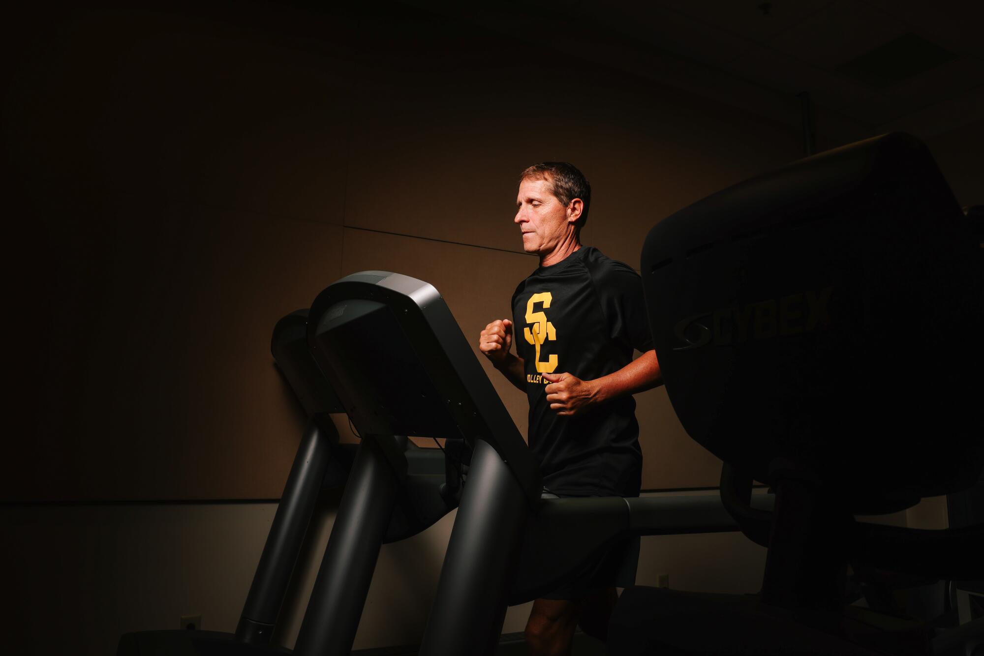 USC men's basketball coach Eric Musselman walks on a treadmill at Galen Center on July 31.