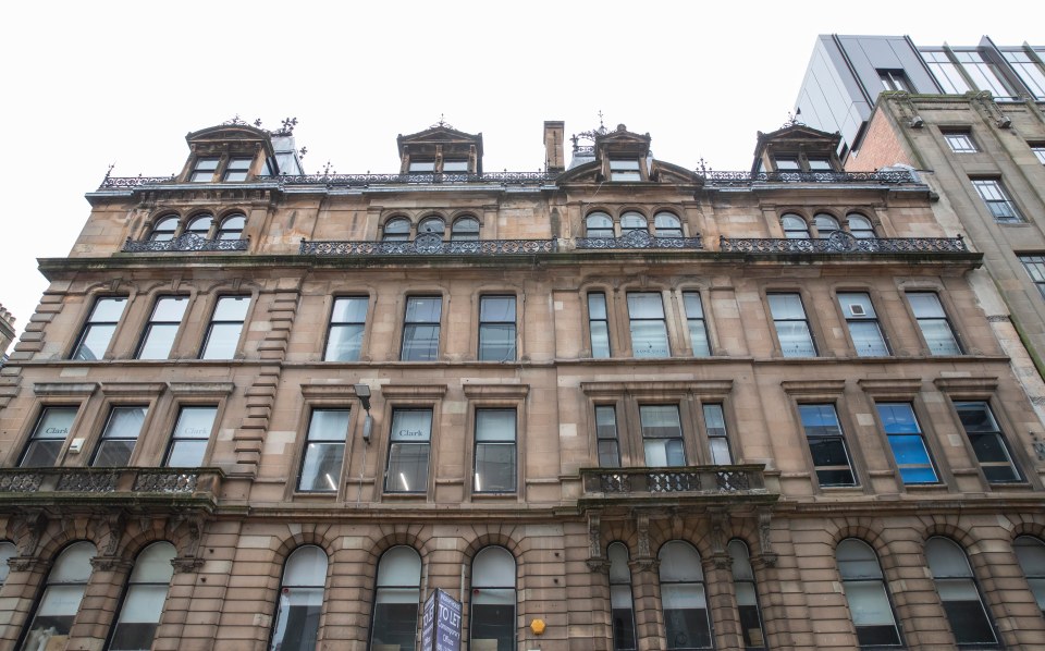 A multi-story stone building with many windows and balconies.