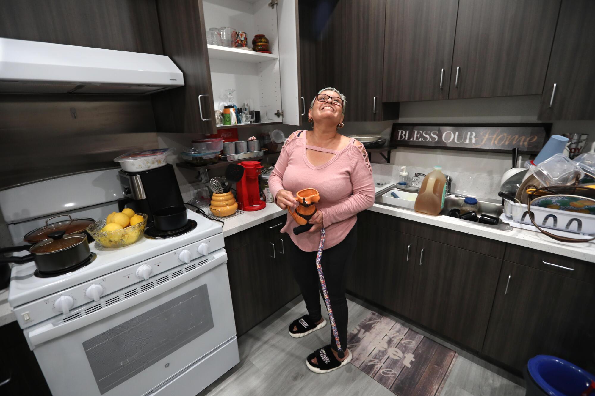 A woman smiles while standing in the kitchen of her new Westlake apartment in March.