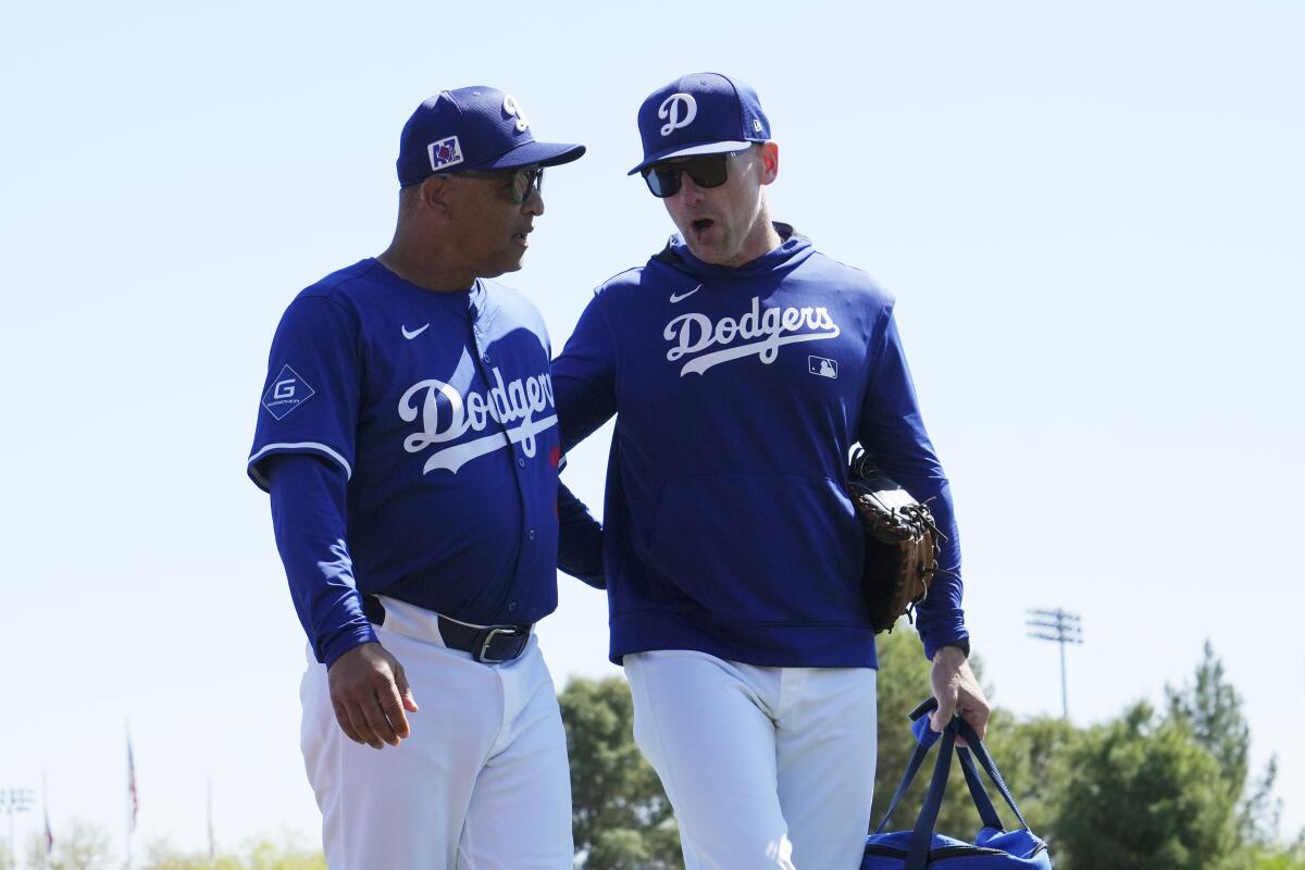 Dodgers manager Dave Roberts, left, talks with coach Brandon McDaniel prior to Sunday's game.