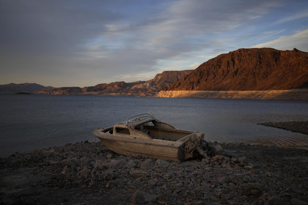 A formerly sunken boat sits high and dry along the shoreline of Lake Mead near Boulder City, Nev., in 2022.