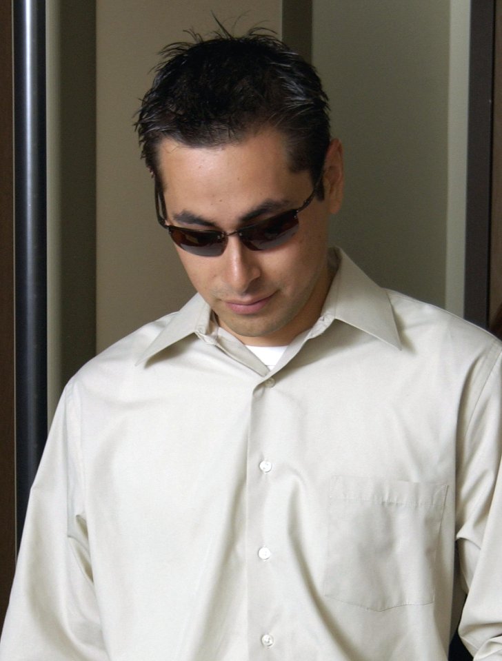 Jason Francia, wearing sunglasses, being escorted to a courtroom.