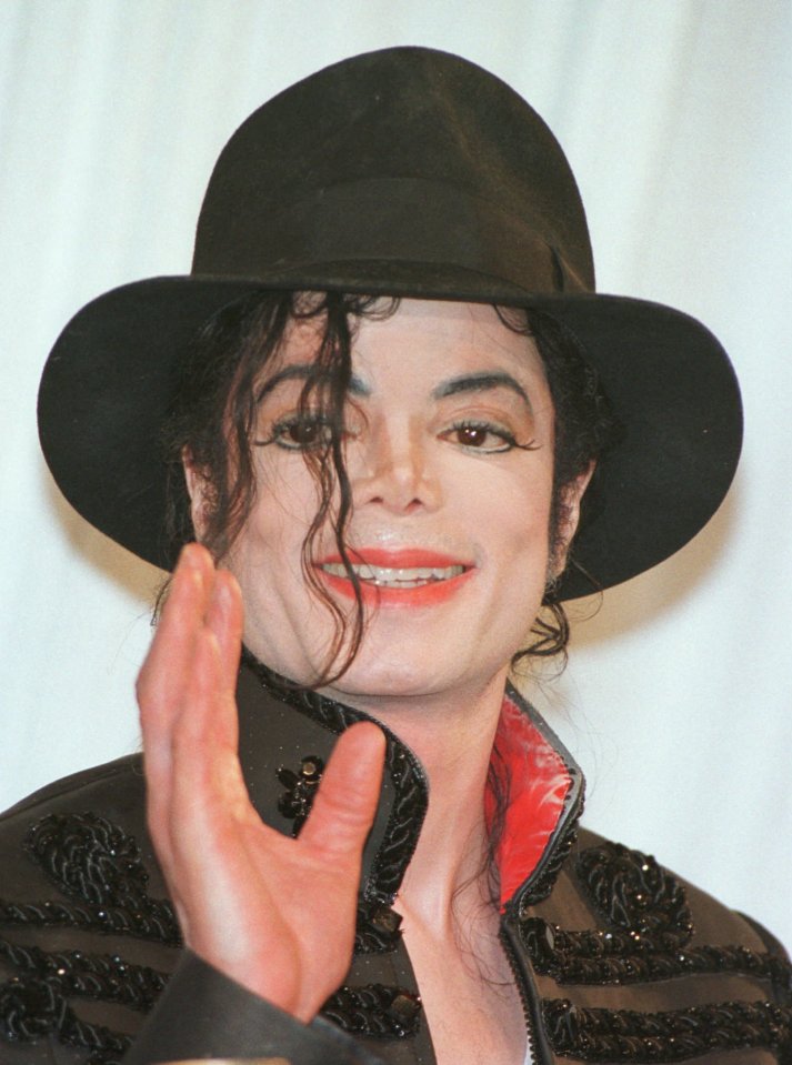 Michael Jackson waves at a press conference.