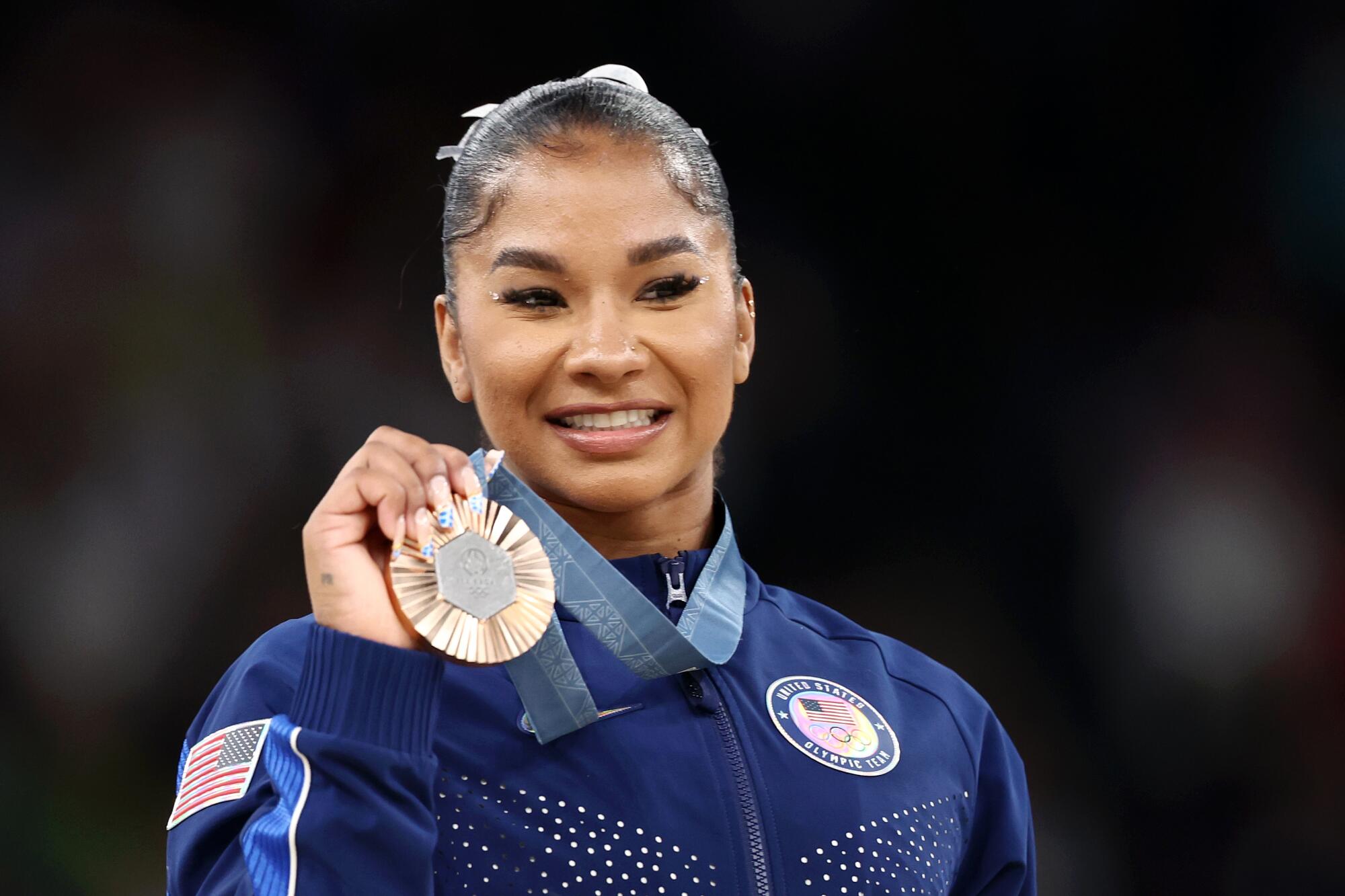 Jordan Chiles holds up the bronze medal the U.S. gymnast won in the floor exercise at the 2024 Paris Olympics.