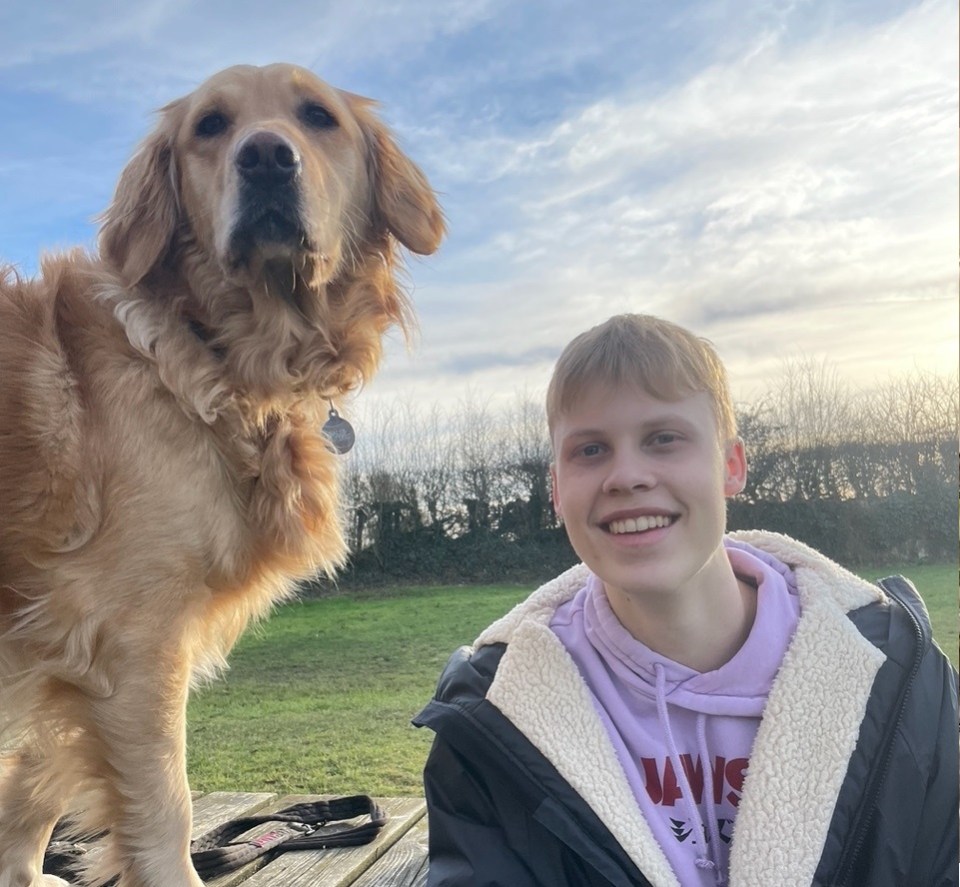 A young man and his golden retriever.