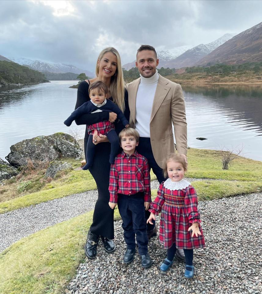 Family portrait in front of a lake and mountains.