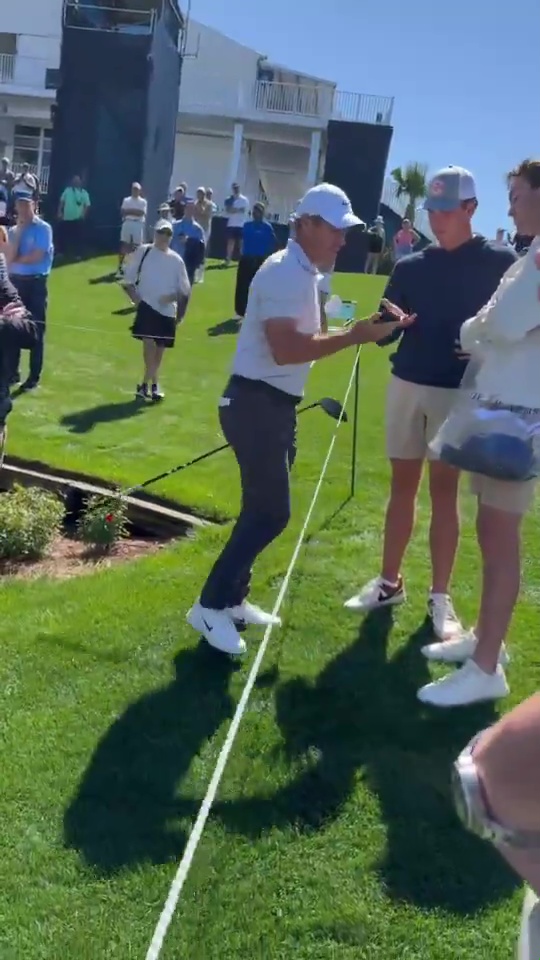 Rory McIlroy taking a fan's phone.